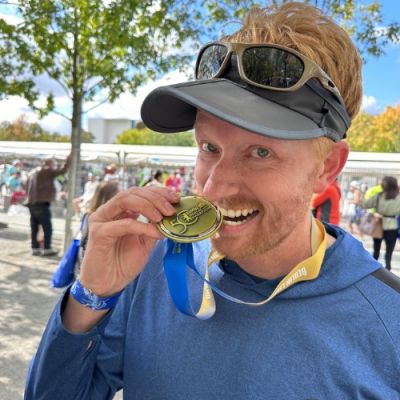 Team Move For Hunger runner, David, holding medal after Berlin marathon.