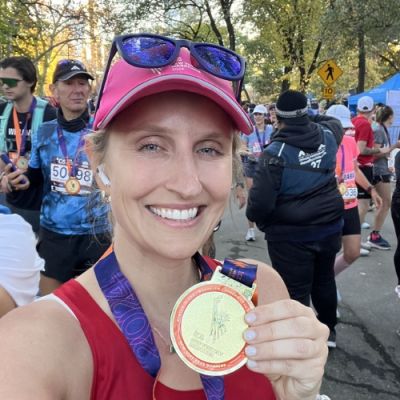 Team Move For Hunger runner, Erika, holding medal after NYC marathon.