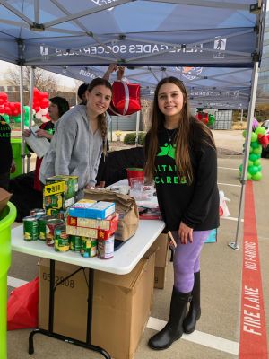 Two girls pose at Altair's annual Grinch themed food drive.